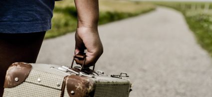 Refugee child goes on the road with her suitcase