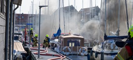 Brand op boten in de Grashaven in Hoorn, brandweer, blussen, brandweerslangen