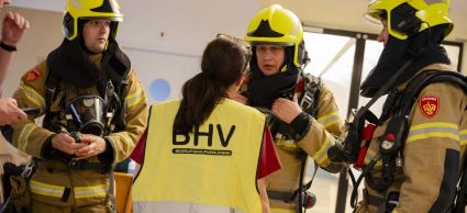 Brandweer en Bhv-medewerkers doen samen een brandoefening in een zorginstelling.