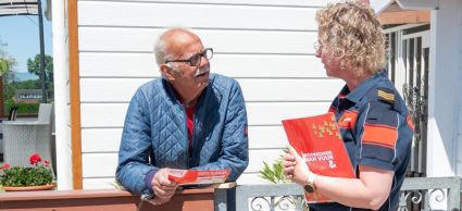 Brandweermedewerker spreekt met campinggasten op een camping