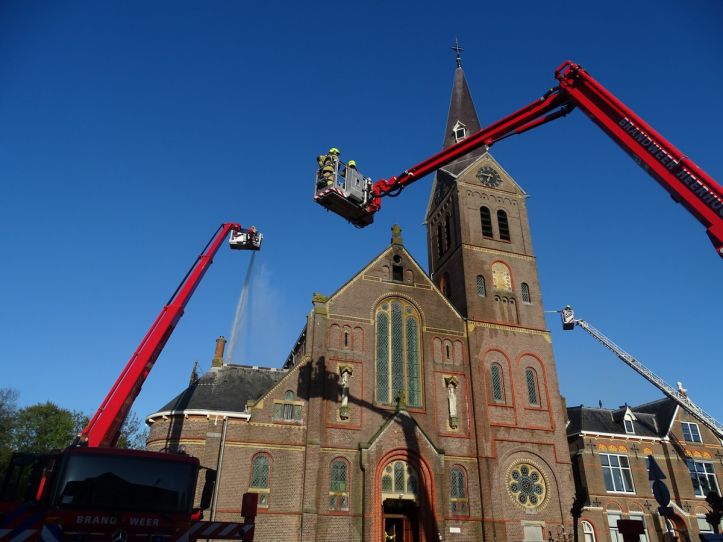 Foto van twee hoogwerkers bij de H. Cornelius kerk in Limmen. 