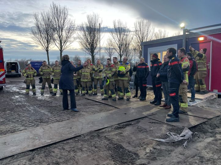 groep brandweermensen staan op terrein nieuwe kazerne