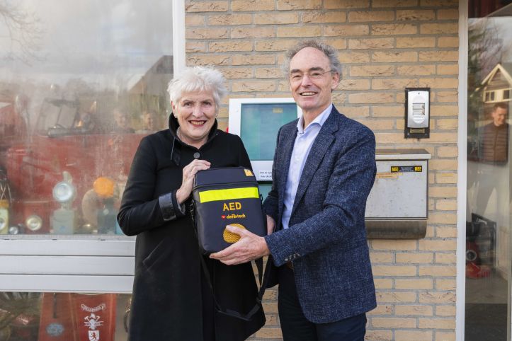 Burgemeester Hafkamp en directeur van de VRNHN Martin Smeekes houden de 1000ste AED vast