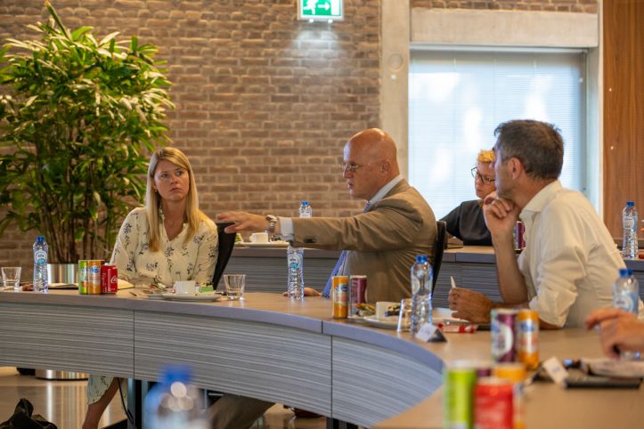 Foto van minister Grapperhaus die spreekt en anderen om hem heen luisteren